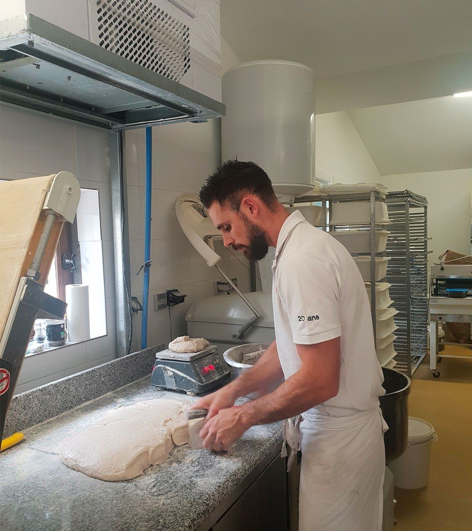 Matthieu façonnant la pâte sur le plan de travail de son fournil